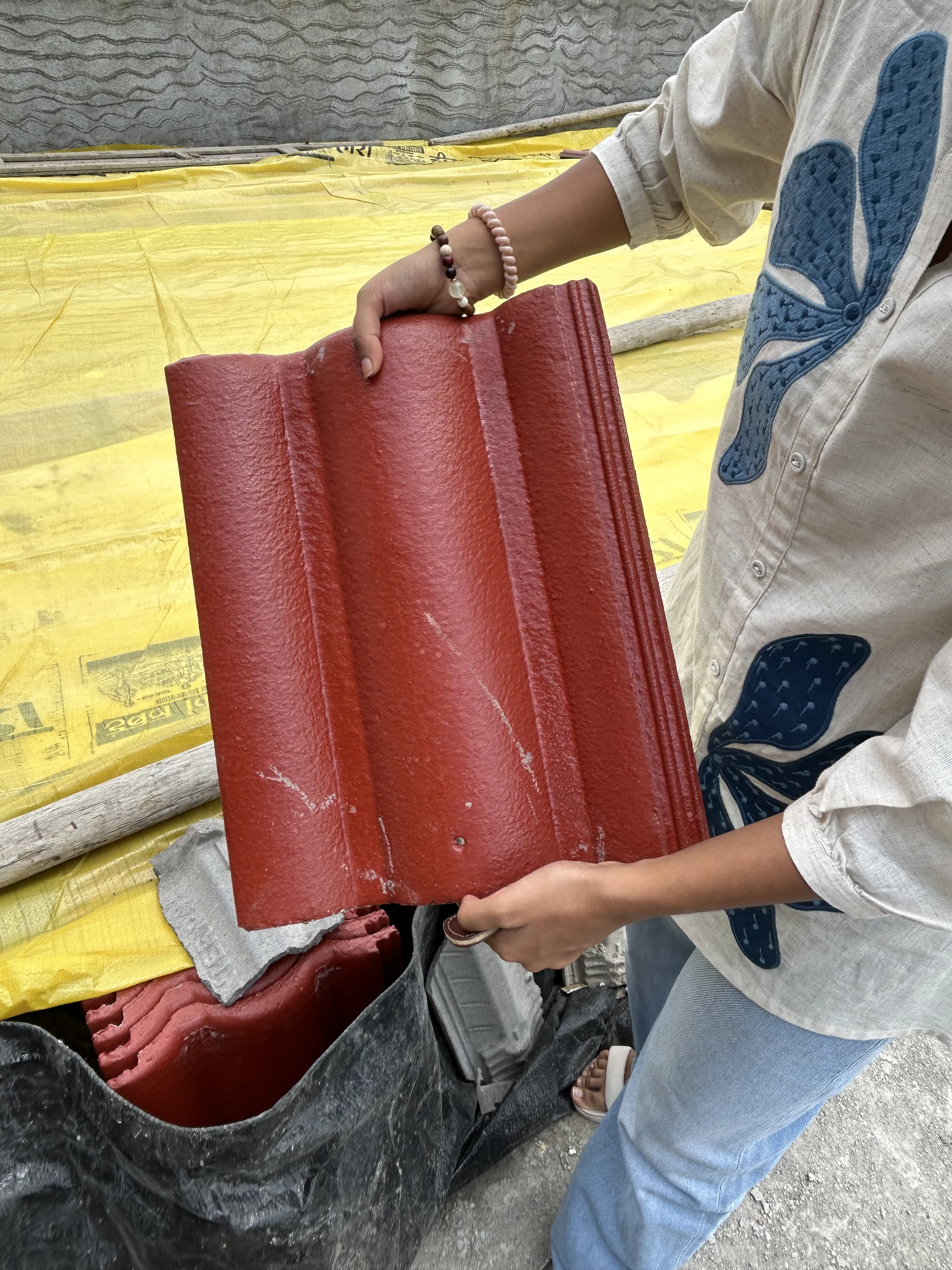 Site photograph: a red Mangalore clay roof tile held in two hands